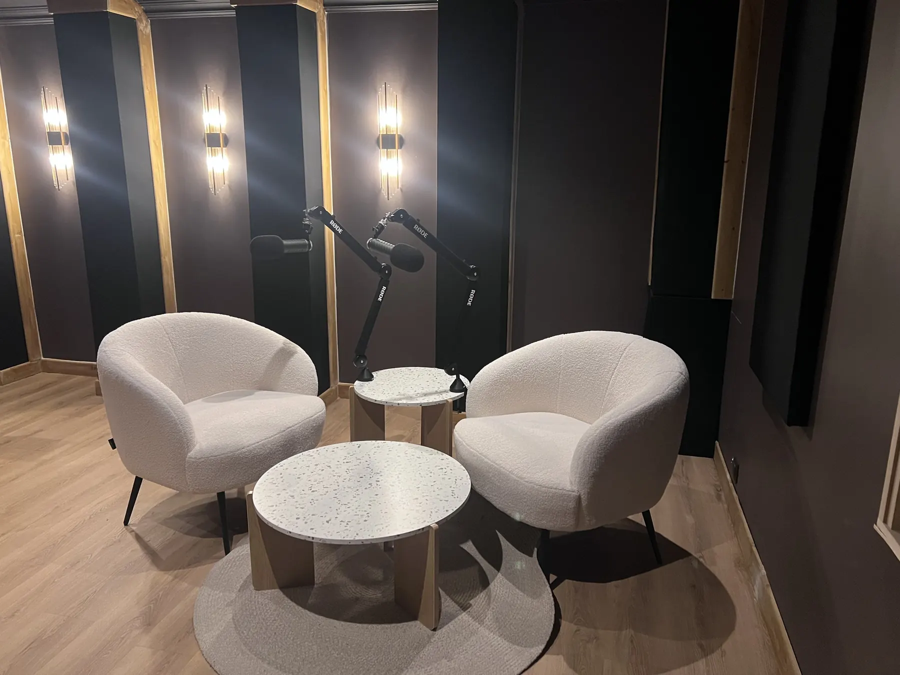 Coin conversation de la salle de podcast avec micros et fauteuils.