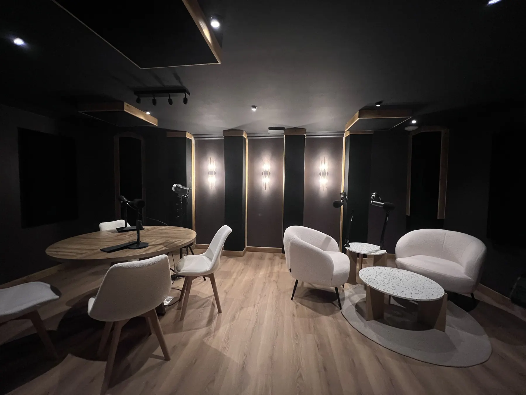 Salle de prise de son du studio podcast : panneaux verticaux en cadres bois, éclairage intégré.